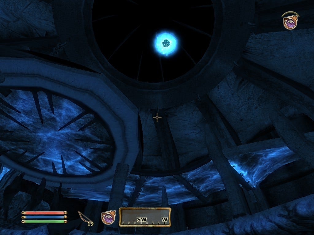 The interior room of the end of an Oblivion Gate with a sigil stone suspended in midair two stories above. All of this picture has a blue hue to it because of Night Vision