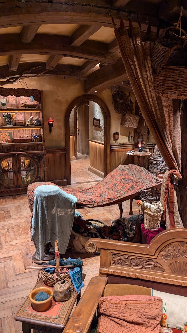 A photo I took of the interior of a Hobbit hole, showing tapestry craft supplies, low ceilings, and winding hallways